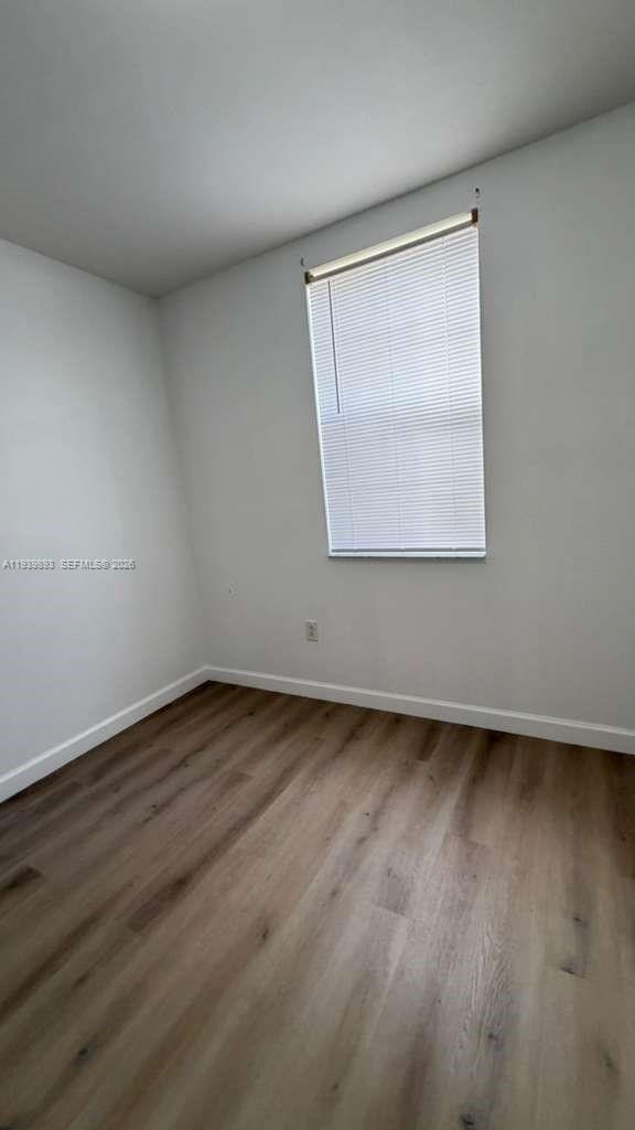 1555 Northeast 33rd Road, Unit 1012 Homestead, FL 33033 - Photo 33 of 54 an empty room with wooden floor and windows
