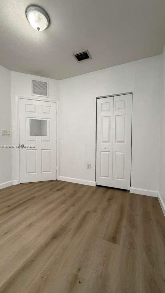 1555 Northeast 33rd Road, Unit 1012 Homestead, FL 33033 - Photo 38 of 54 an empty room with wooden floor and windows