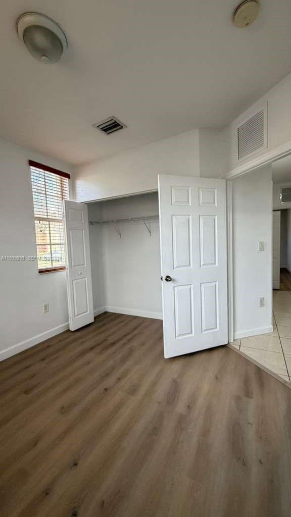 1555 Northeast 33rd Road, Unit 1012 Homestead, FL 33033 - Photo 43 of 54 an empty room with wooden floor and windows