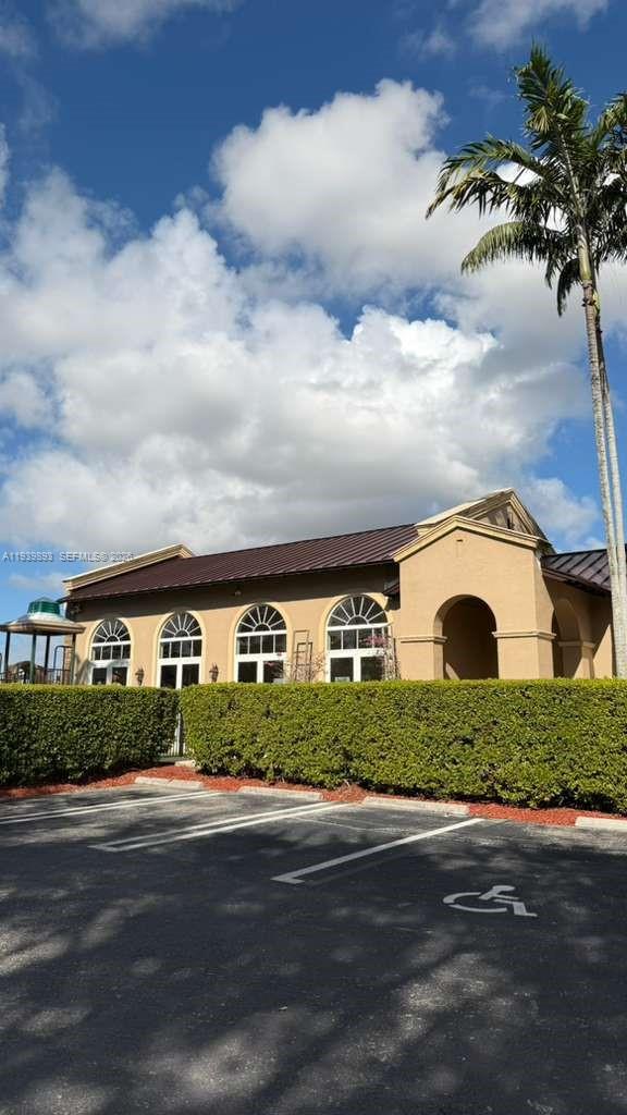 1555 Northeast 33rd Road, Unit 1012 Homestead, FL 33033 - Photo 49 of 54 a front view of a house with a yard and garage