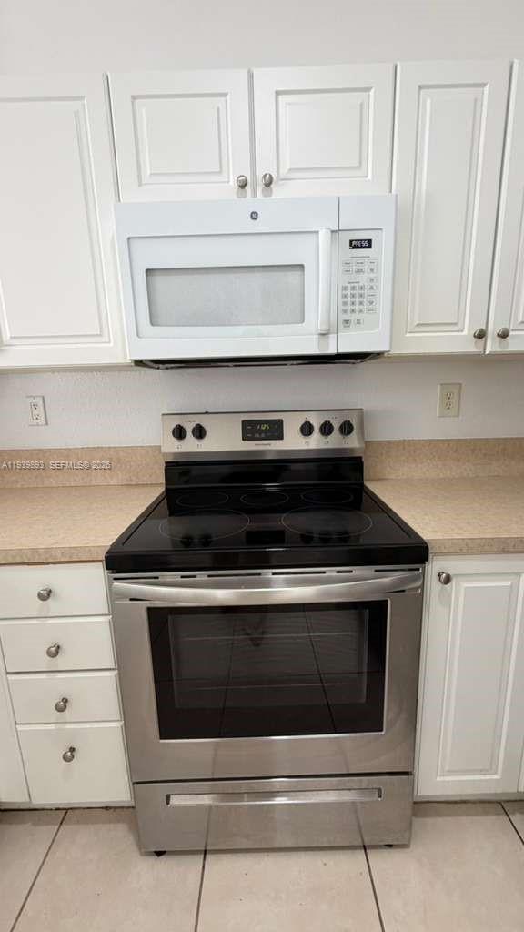 1555 Northeast 33rd Road, Unit 1012 Homestead, FL 33033 - Photo 9 of 54 a stove top oven sitting inside of a kitchen
