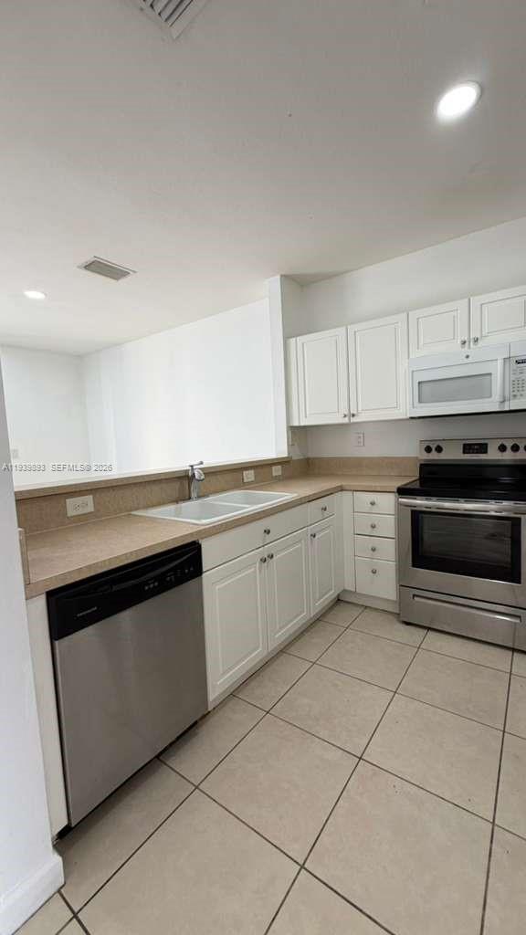 1555 Northeast 33rd Road, Unit 1012 Homestead, FL 33033 - Photo 10 of 54 a kitchen with cabinets appliances and a sink