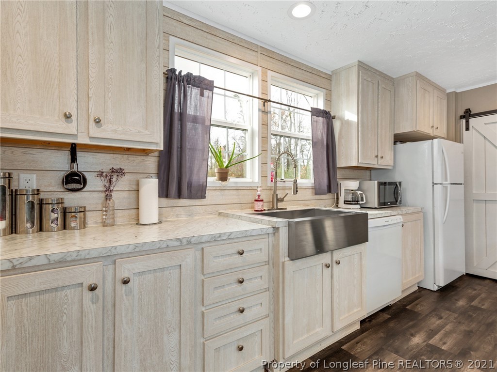 753 Mitchell Loop Road Roseboro, NC 28382 - Photo 13 of 30 a kitchen with granite countertop white cabinets and white appliances