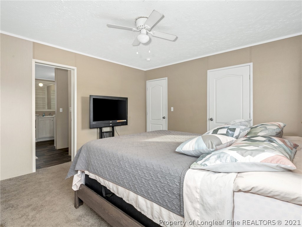 753 Mitchell Loop Road Roseboro, NC 28382 - Photo 17 of 30 a bedroom with a bed and a flat screen tv