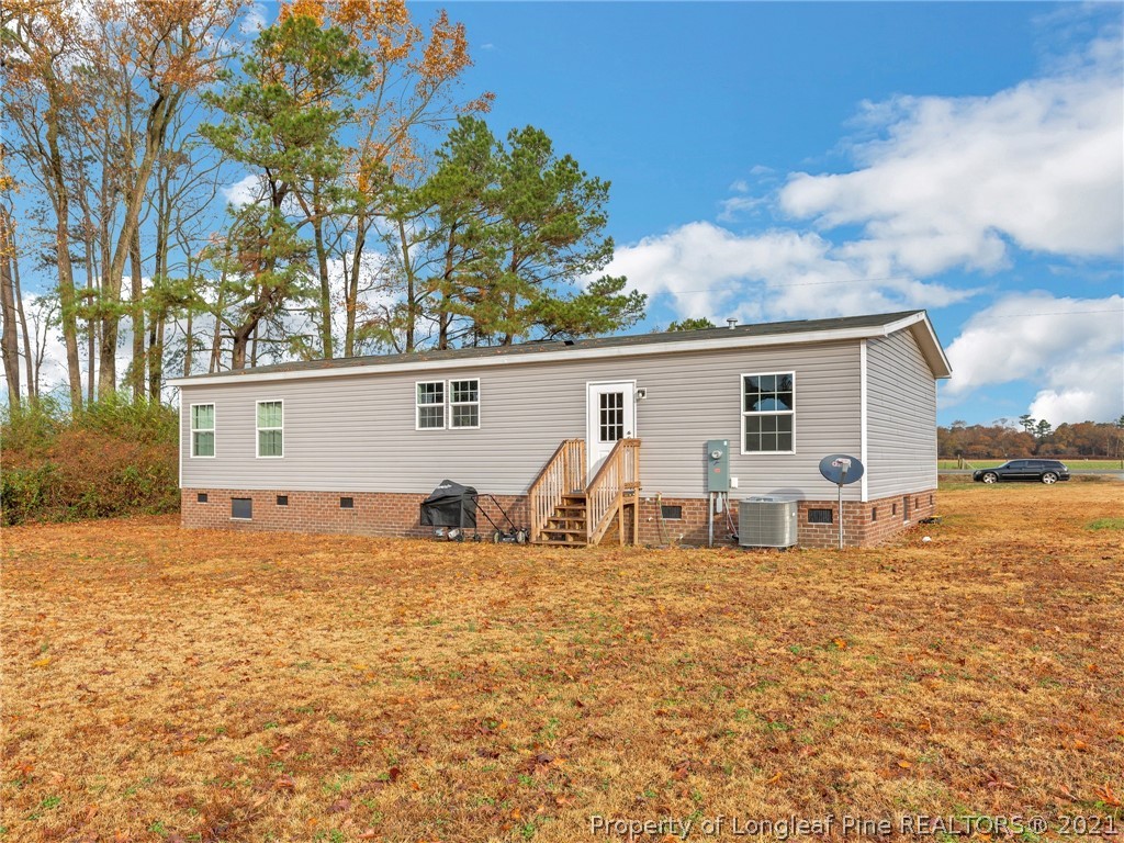 753 Mitchell Loop Road Roseboro, NC 28382 - Photo 29 of 30 a backyard of a house with barbeque oven and table and chairs