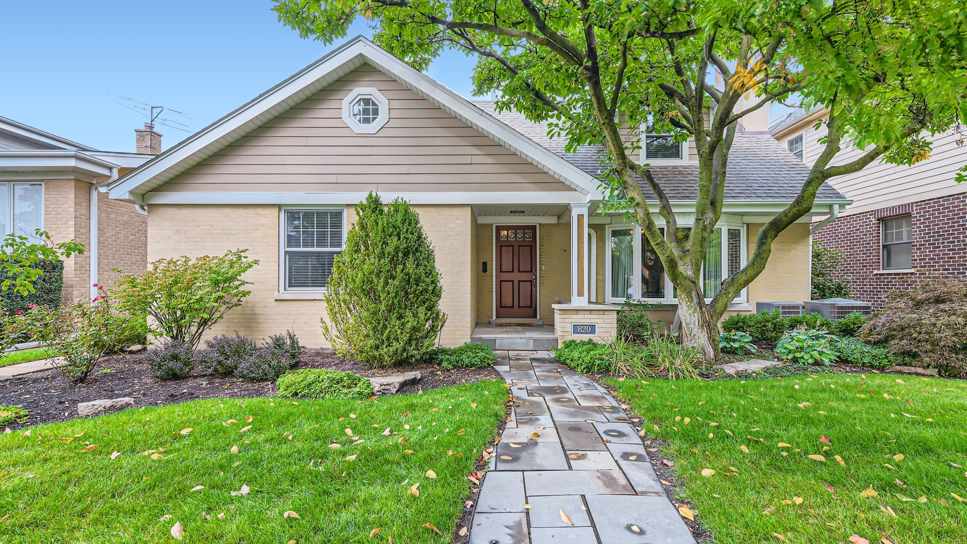 a view of a house with a yard and potted plants