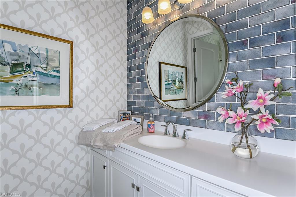 2621 Seychelles Circle, Unit 1806 Naples, FL 34112 - Photo 14 of 25 a bathroom with a sink vanity and a mirror