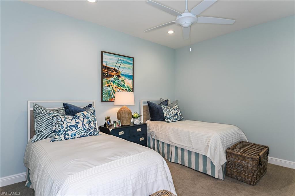 2621 Seychelles Circle, Unit 1806 Naples, FL 34112 - Photo 15 of 25 a bedroom with two beds and a chandelier