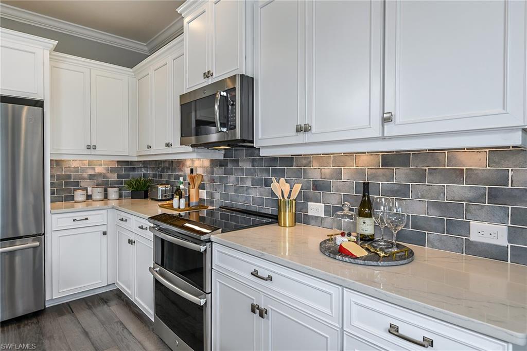 2621 Seychelles Circle, Unit 1806 Naples, FL 34112 - Photo 7 of 25 a kitchen with a sink and cabinets