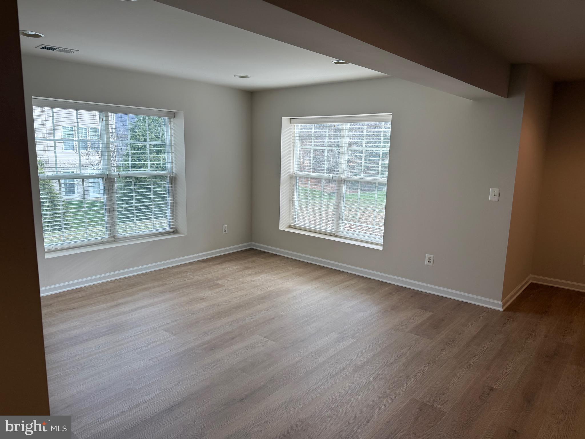 6231 Glen Wood Loop Manassas, VA 20112 - Photo 9 of 18 an empty room with wooden floor and windows