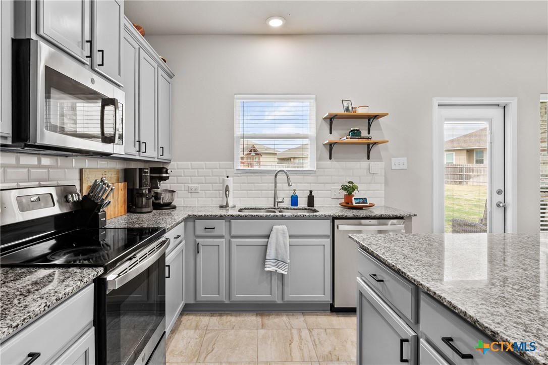7468 Mossy Ridge Lane Temple, TX 76502 - Photo 13 of 38 a kitchen with stainless steel appliances granite countertop a stove sink and cabinets