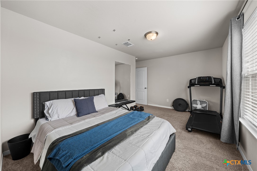 7468 Mossy Ridge Lane Temple, TX 76502 - Photo 30 of 38 a bedroom with bed and a large window