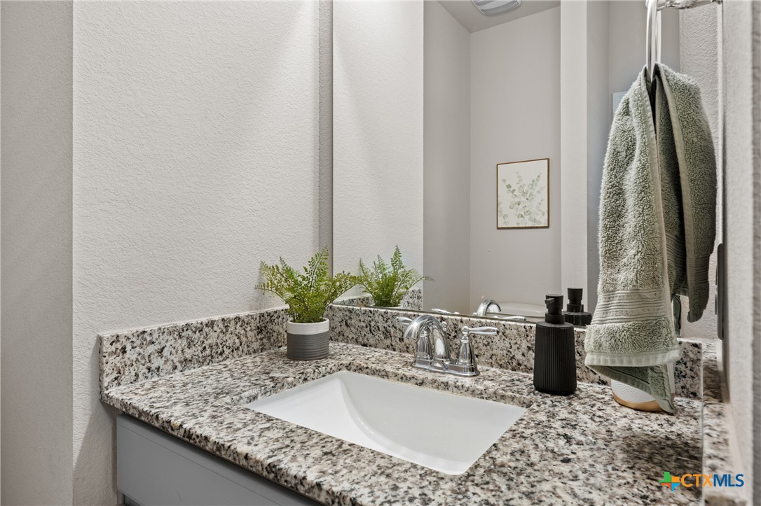 7468 Mossy Ridge Lane Temple, TX 76502 - Photo 8 of 38 a bathroom with a granite countertop sink and a mirror