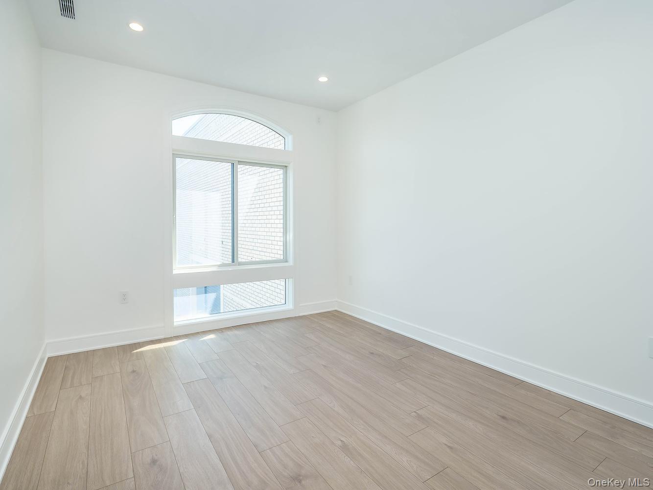 24 Lumber Road, Unit 1 Roslyn, NY 11576 - Photo 13 of 18 an empty room with wooden floor and windows