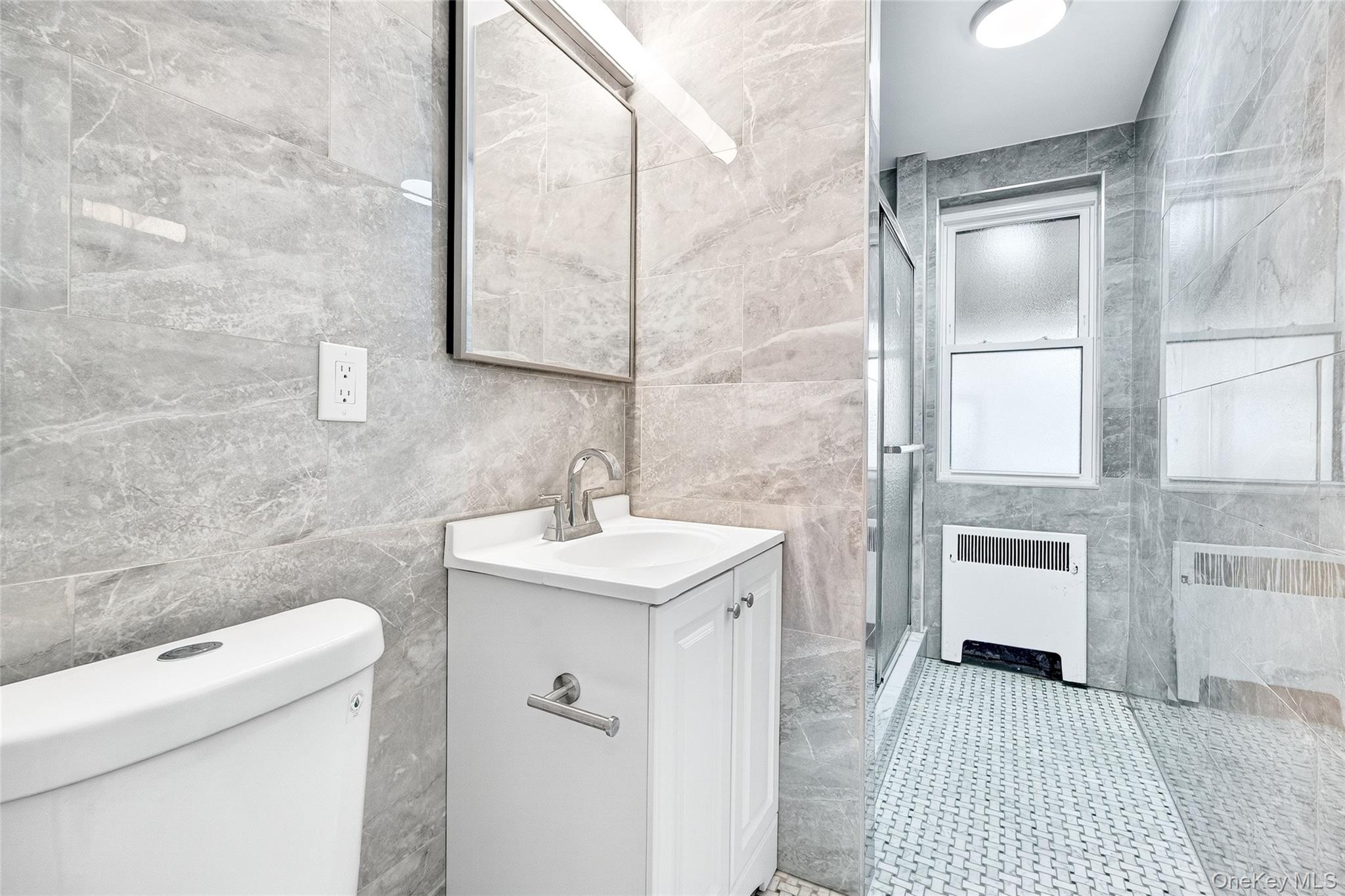 1458 Rowland Street Bronx, NY 10461 - Photo 10 of 49 Full bathroom with tile walls, a stall shower, vanity, and radiator heating unit