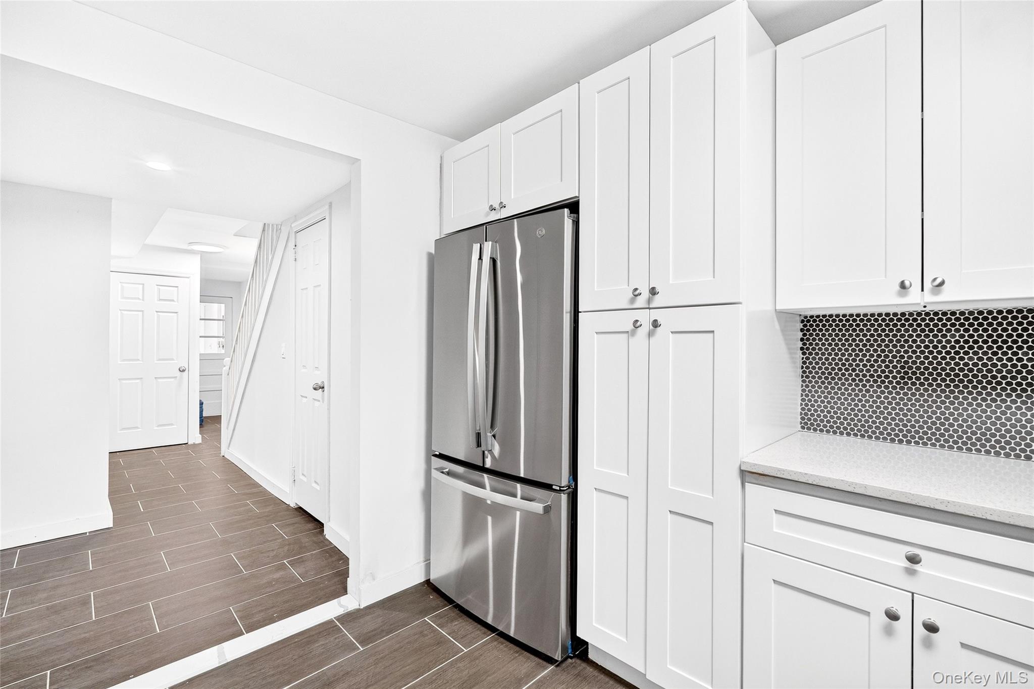 1458 Rowland Street Bronx, NY 10461 - Photo 29 of 49 Kitchen with freestanding refrigerator, wood finish floors, white cabinets, and light stone counters