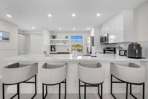 a kitchen with granite countertop sink table and chairs