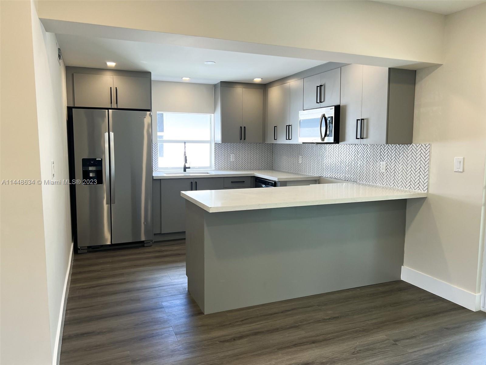 Pinewood Miami, FL 33167 - Photo 13 of 31 a kitchen with kitchen island a sink appliances and cabinets