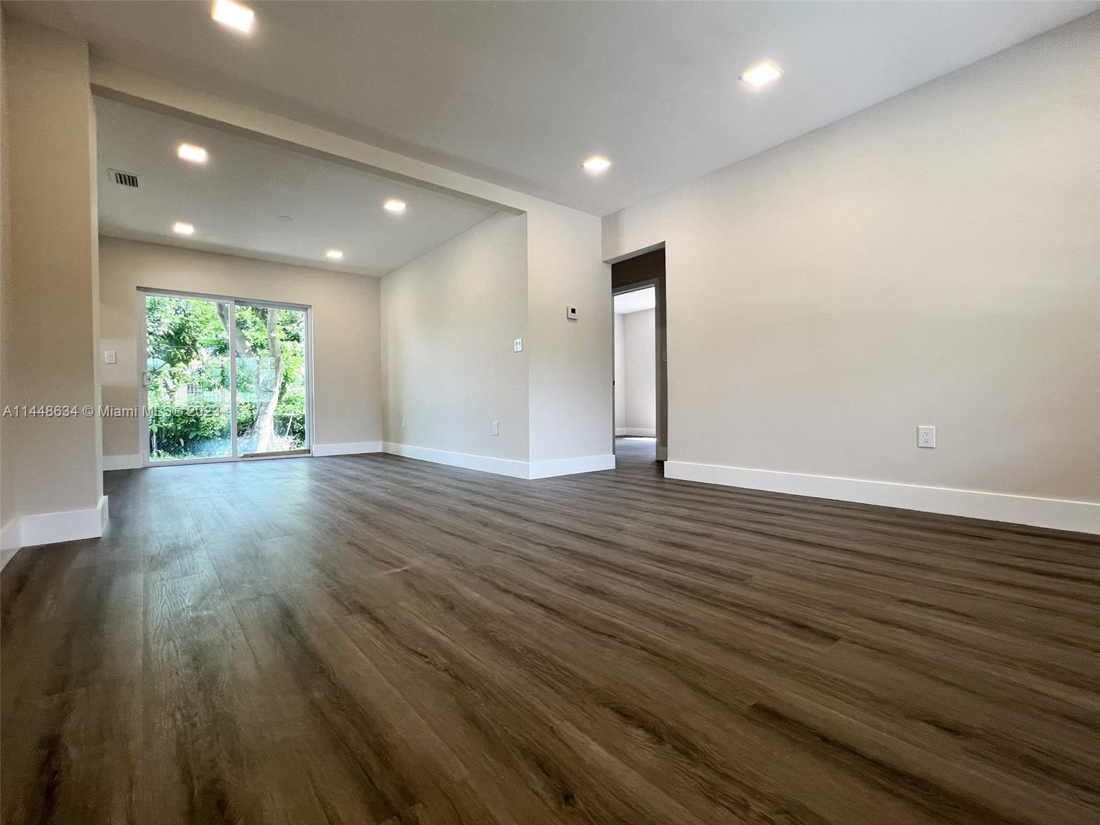 Pinewood Miami, FL 33167 - Photo 16 of 31 an empty room with wooden floor and windows