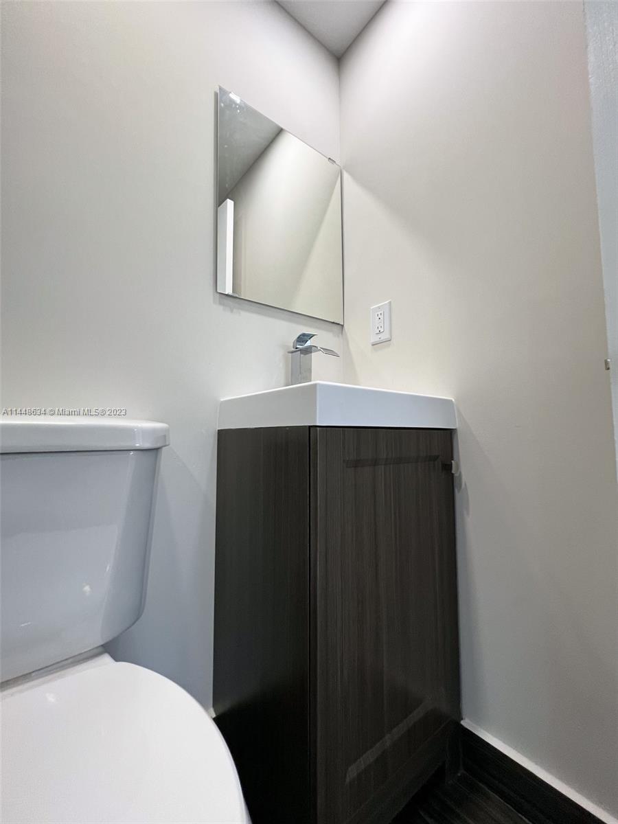 Pinewood Miami, FL 33167 - Photo 18 of 31 a bathroom with a toilet sink and mirror