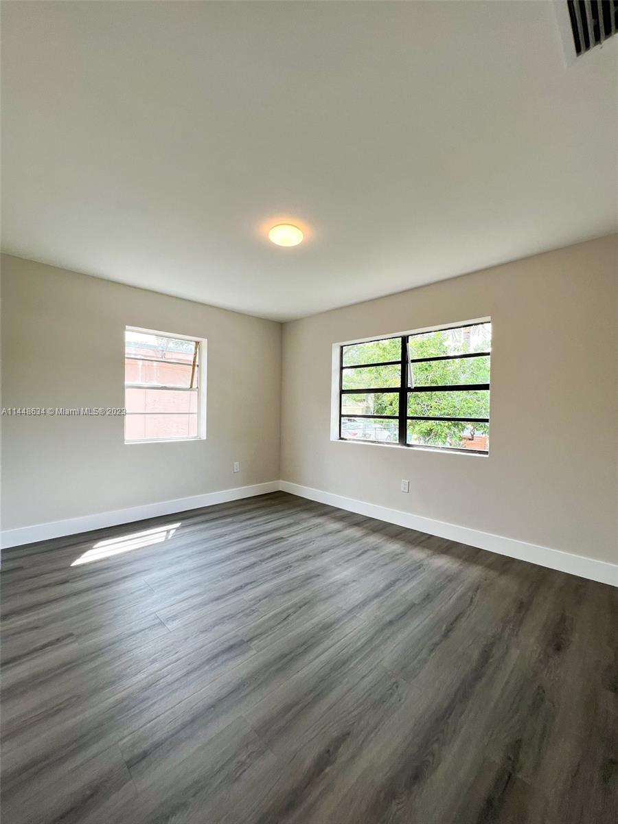 Pinewood Miami, FL 33167 - Photo 19 of 31 an empty room with wooden floor and windows