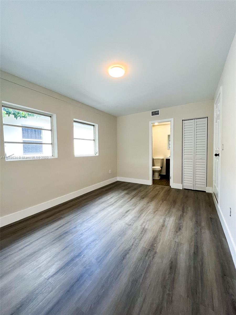Pinewood Miami, FL 33167 - Photo 23 of 31 an empty room with wooden floor and windows