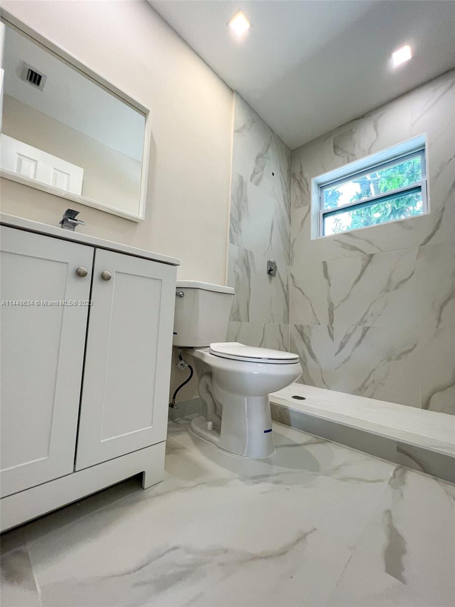 Pinewood Miami, FL 33167 - Photo 26 of 31 a bathroom with a toilet sink and a mirror