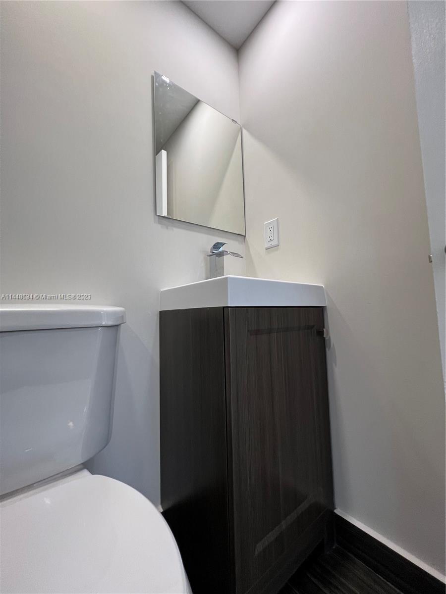 Pinewood Miami, FL 33167 - Photo 28 of 31 a bathroom with a toilet sink and mirror