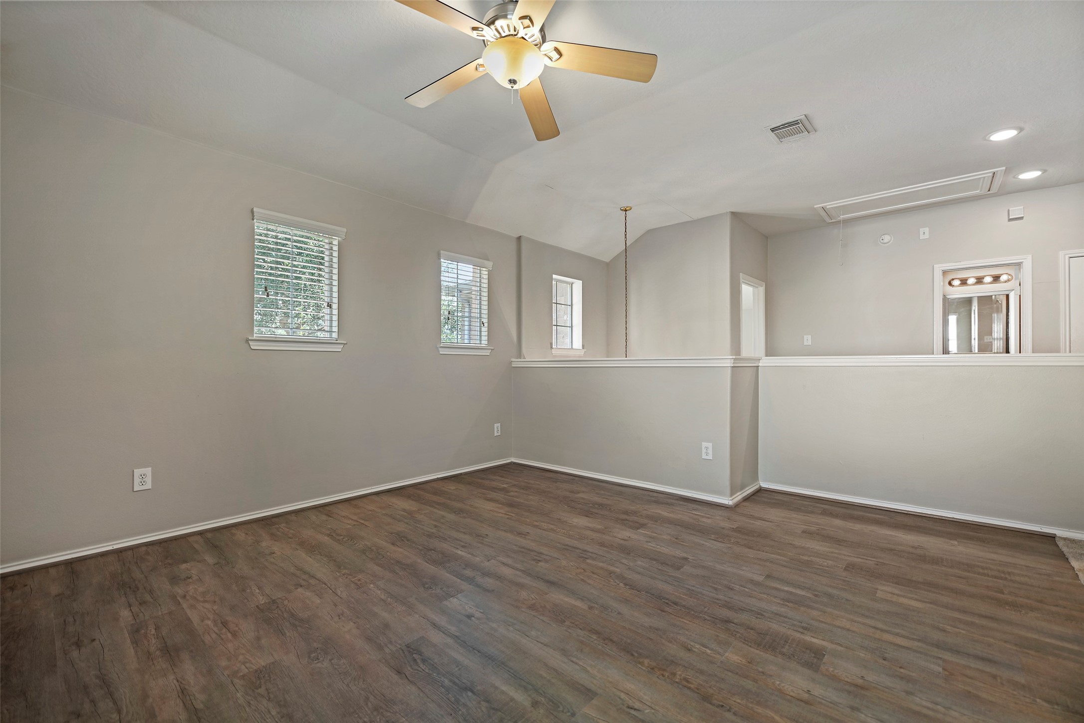 20739 Stewart Crest Lane Cypress, TX 77433 - Photo 15 of 35 a view of an empty room with wooden floor and a ceiling fan