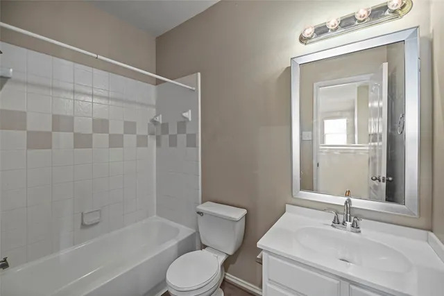a bathroom with a bathtub shower sink vanity mirror and toilet