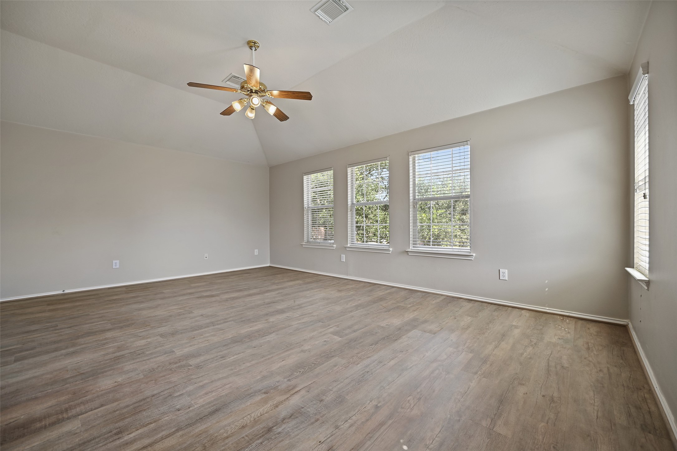 20739 Stewart Crest Lane Cypress, TX 77433 - Photo 25 of 35 an empty room with wooden floor fan and windows