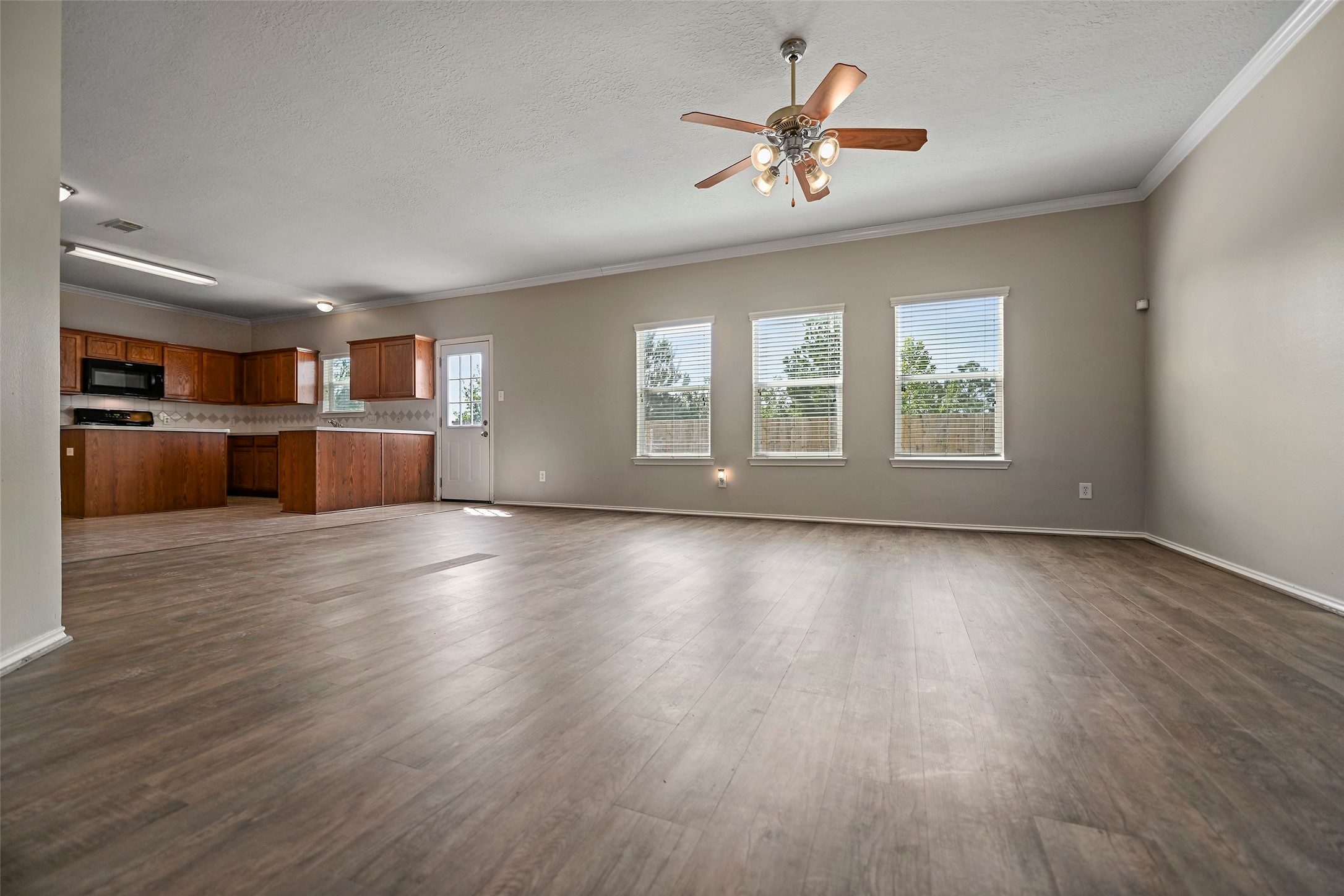 20739 Stewart Crest Lane Cypress, TX 77433 - Photo 7 of 35 a view of an empty room with a kitchen and wooden floor