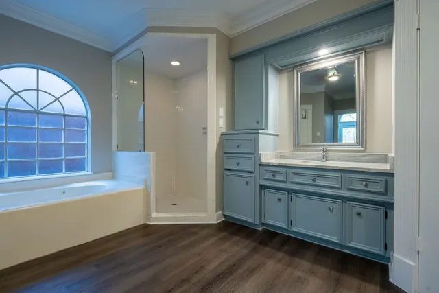 a bathroom with a double vanity sink a mirror and a bathtub