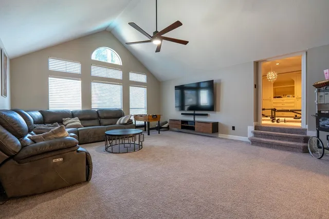 a living room with furniture a large window and a flat screen tv