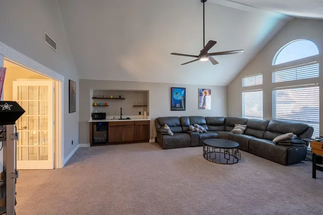 a living room with furniture a ceiling fan and a window