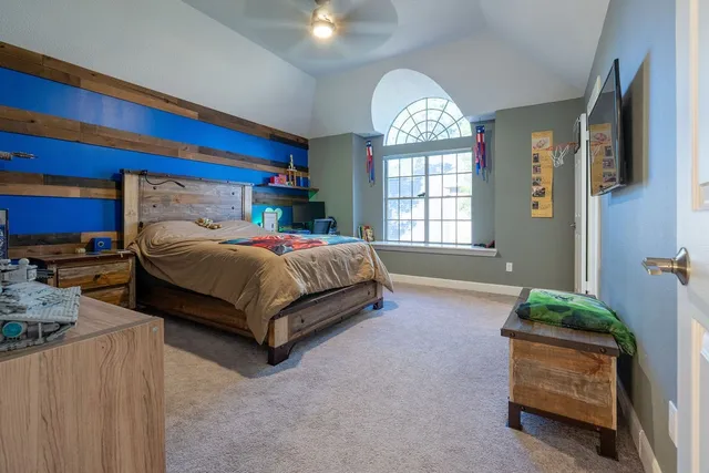 a bedroom with a bed and a large window