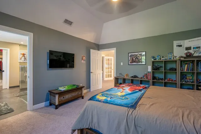 a bedroom with bed and a flat screen tv