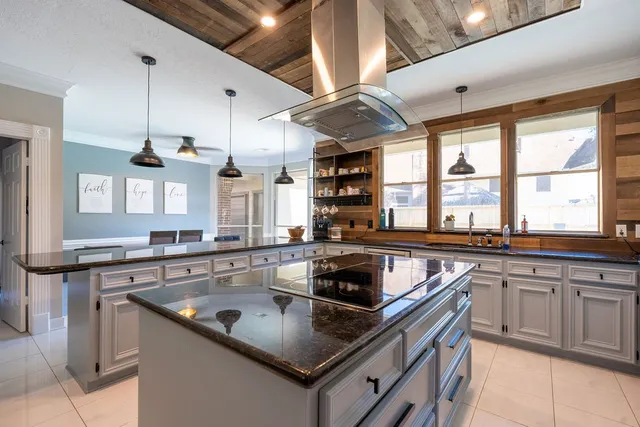 a kitchen with stainless steel appliances granite countertop a sink a stove and a wooden floors