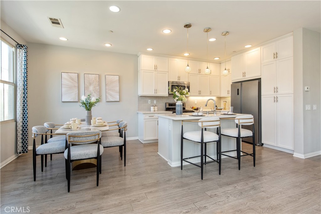 68 Origin Irvine, CA 92618 - Photo 11 of 43 a dining room with kitchen island a dining table chairs with wooden floor and kitchen view