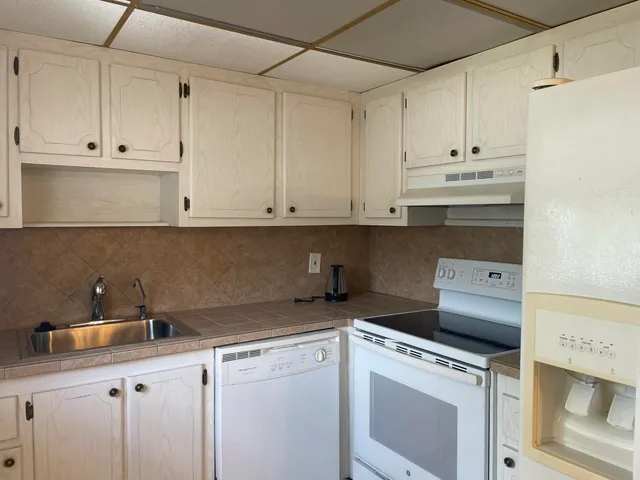 a kitchen with appliances a sink and cabinets