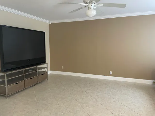 a view of an empty room with a flat screen tv and a fan