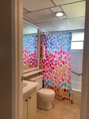 a white toilet sitting next to a shower curtain