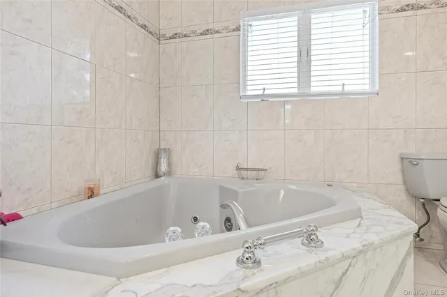 a white bath tub sitting in a bathroom next to a window