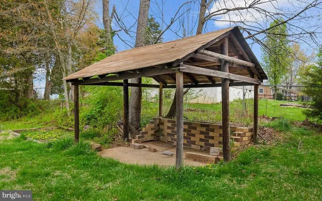 a view of a tiny house with a small yard and sitting area