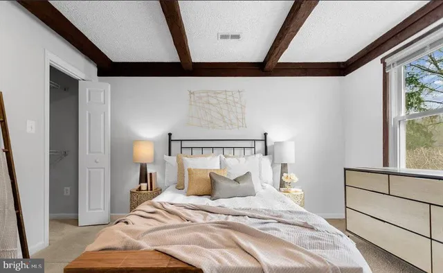 a bed sitting in a bedroom next to a window