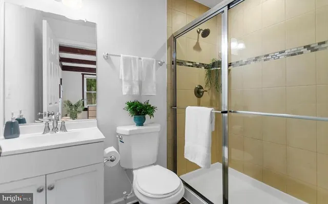 a bathroom with a sink a toilet a mirror and shower