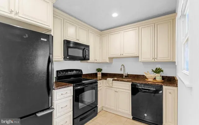 a kitchen with granite countertop white cabinets and stainless steel appliances