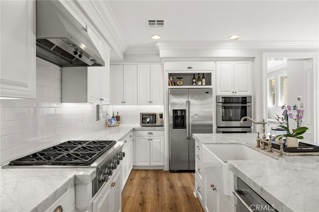 21 Snow Bush Street Ladera Ranch, CA 92694 - Photo 13 of 73 a kitchen with a sink stainless steel appliances and white cabinets