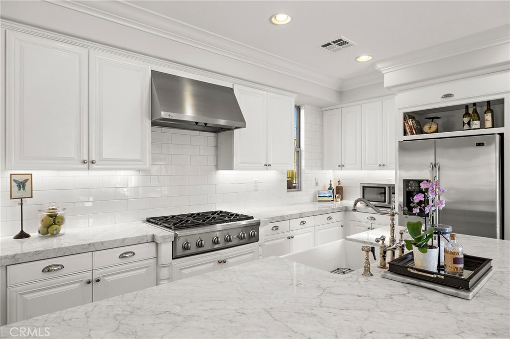 21 Snow Bush Street Ladera Ranch, CA 92694 - Photo 14 of 73 a kitchen with white cabinets and appliances