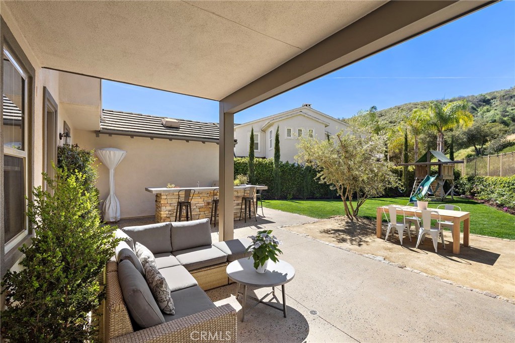 21 Snow Bush Street Ladera Ranch, CA 92694 - Photo 38 of 73 a view of a patio with couches and chairs under an umbrella